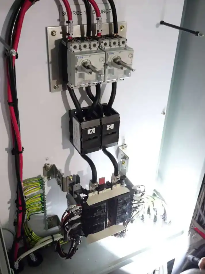 Electrical transfer switch assembly inside a marine panel